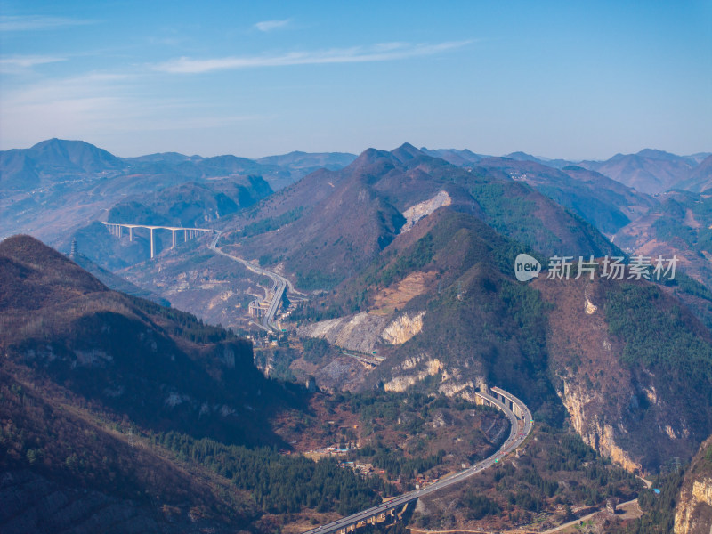 山间城镇全景，高架公路贯穿其中