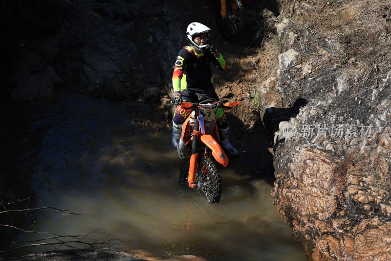 越野摩托赛驶过山涧溪水坑车手