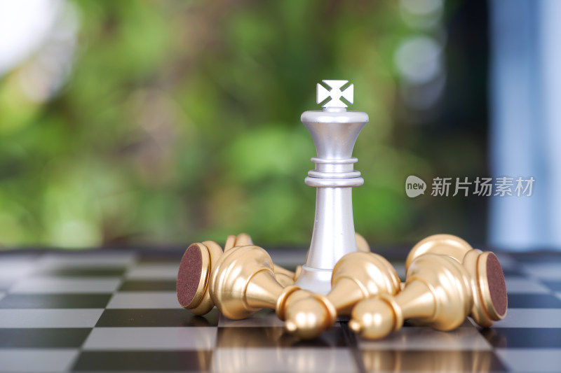 一堆金色兵棋子围绕的银色国王棋子