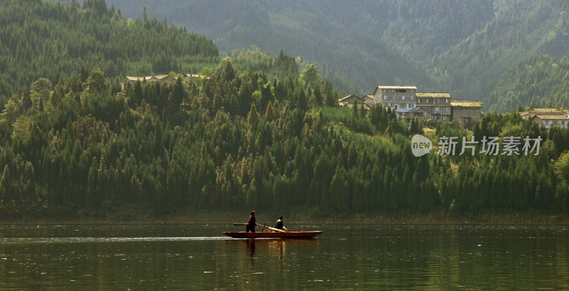 两人泛舟湖面山林风景