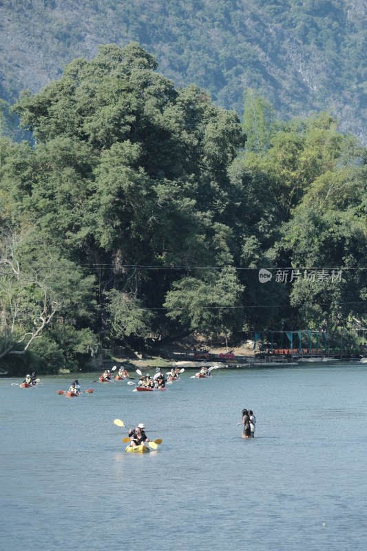 老挝万荣河上多人划艇与山林风景