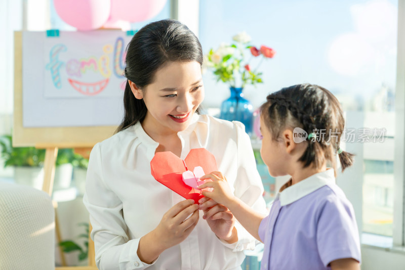 老师和小女孩一起折纸