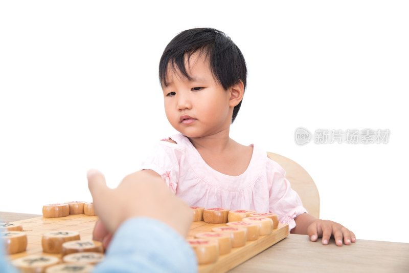 白背景前中国三岁的小女孩正在下中国象棋