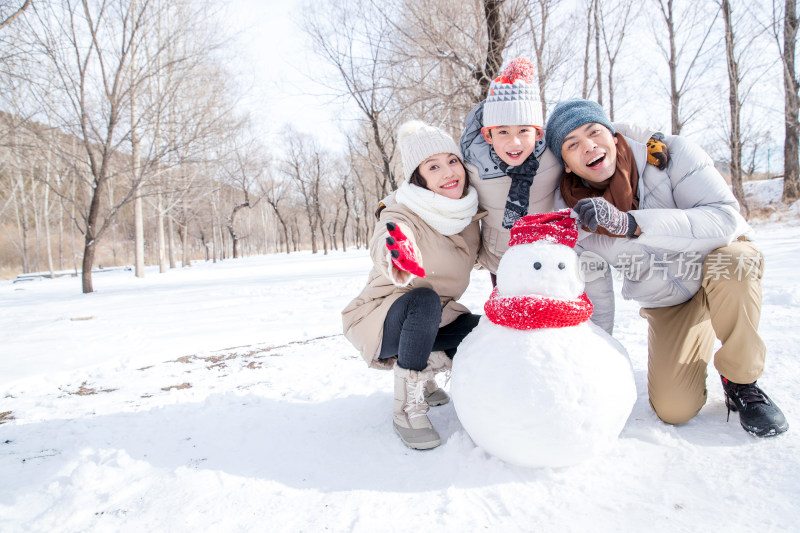 一家三口在雪地里堆雪人