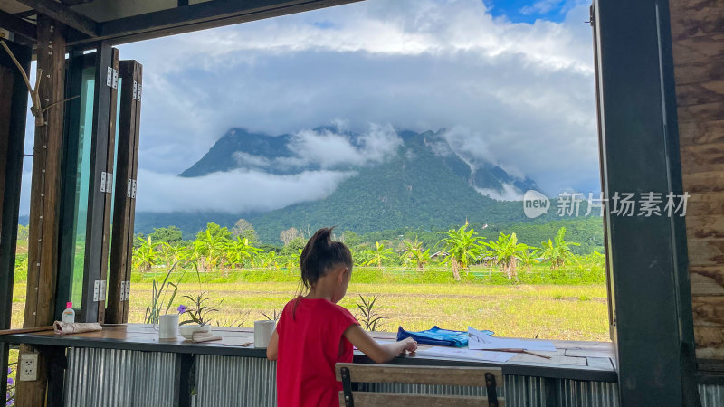 小女孩窗前眺望远山风景