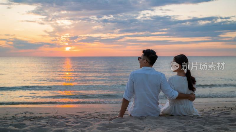 夕阳下一对情侣在海边