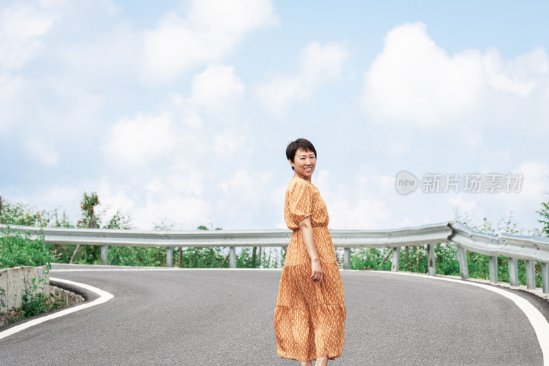 晴朗的夏天午后走在盘山公路上的中国女性