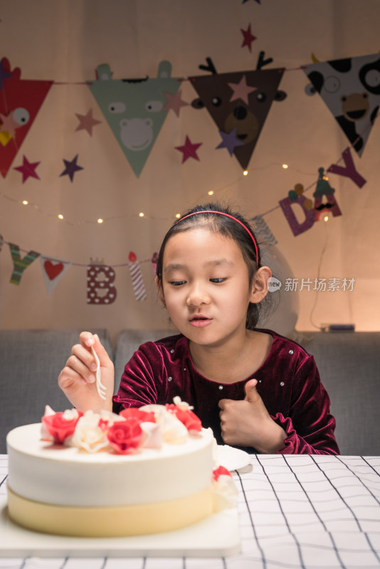 在生日会上吃生日蛋糕的中国女孩