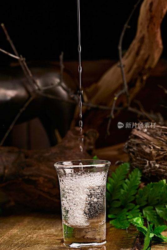 木板上摆放的酒具倒入清澈的白酒激起酒花