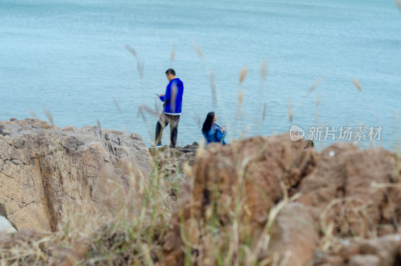 海边草丛后的一对男女