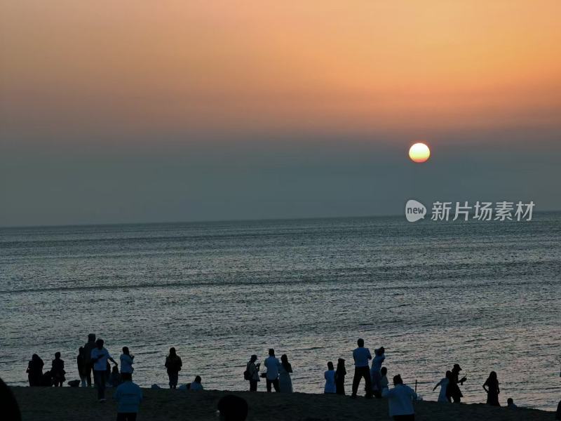 夕阳下海边惬意的人们