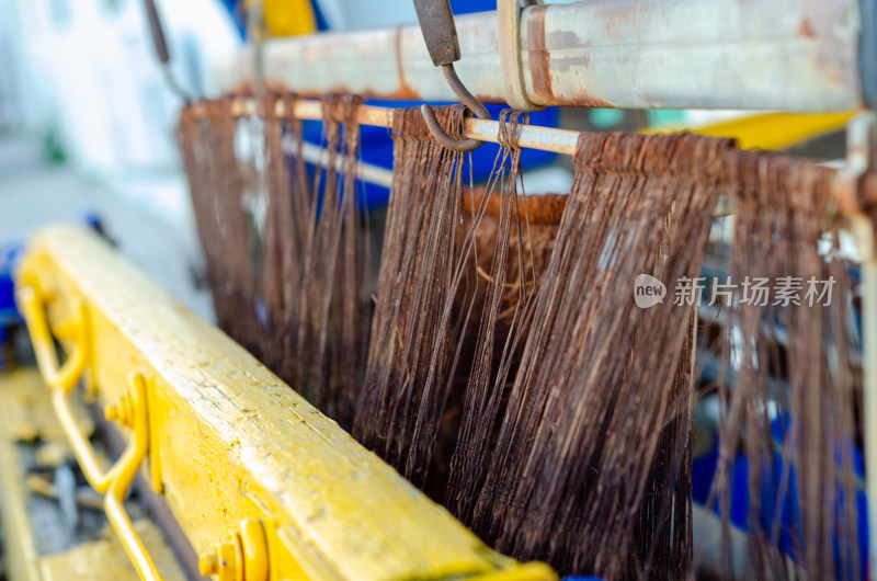 青岛纺织谷工业机械织布机上悬挂的丝状物体