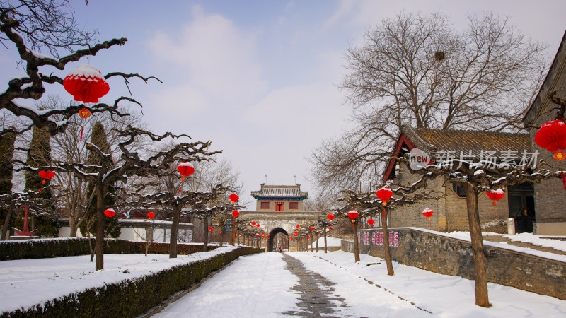 雪后老龙头古建筑旁挂满红灯笼的小径