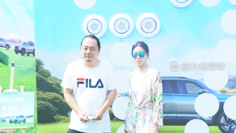 男女站在汽车宣传背景前