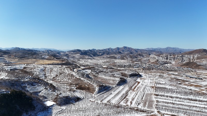 被雪覆盖的山间田野航拍全景