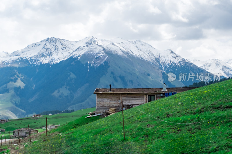 新疆琼库什台雪山下草原上的小木屋