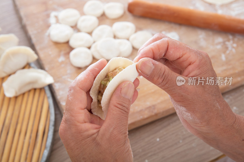 俯视拍摄黄皮肤的双手正在捏饺子