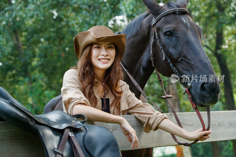 围栏旁的个性青年女人和马