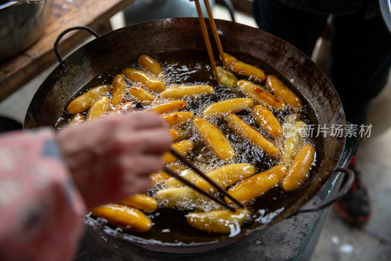 用筷子翻动油炸食物的烹饪过程