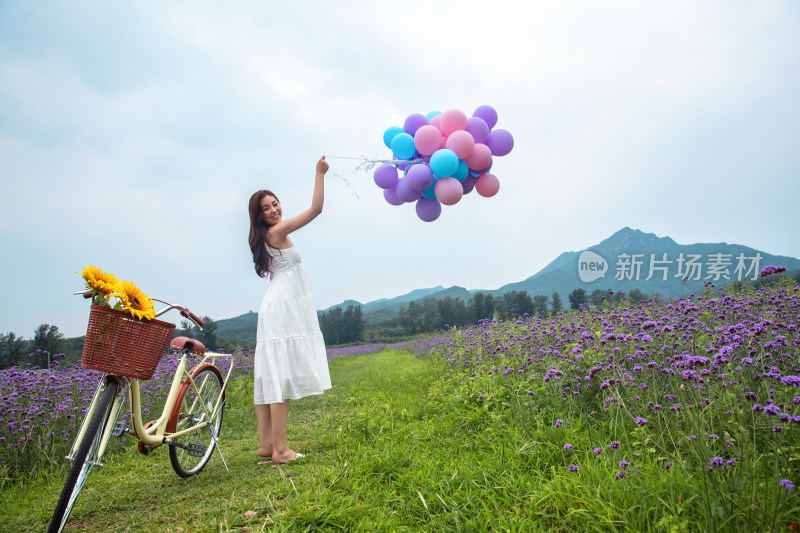 青年女人在花海里拿着气球