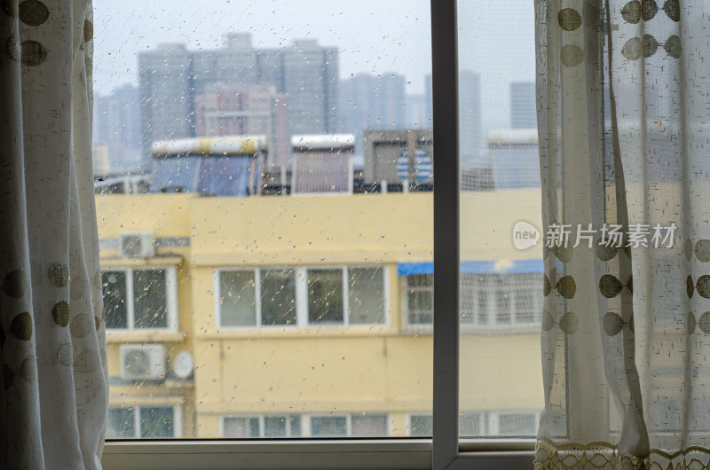 透过窗户看雨中城市建筑