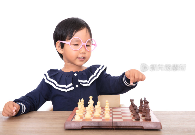 戴着眼镜框可爱的小女孩在下国际象棋