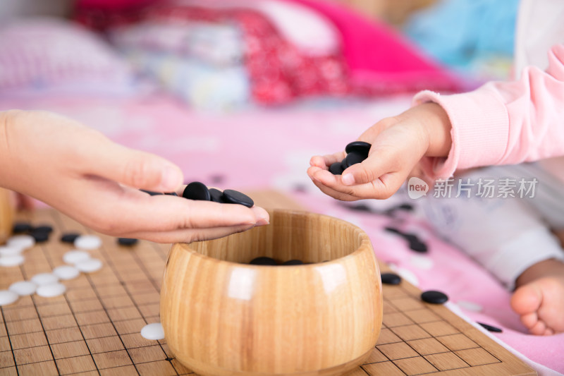 一只小手正把棋子放入棋盒中