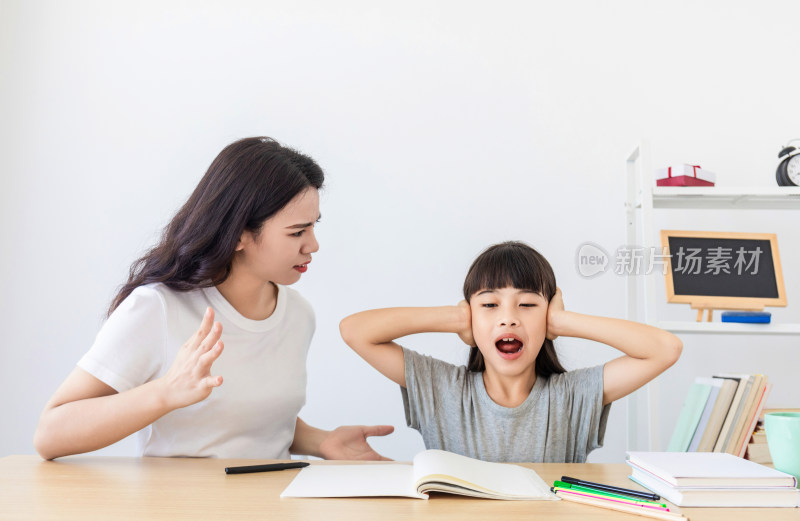 一名中国妈妈在辅导女儿写作业