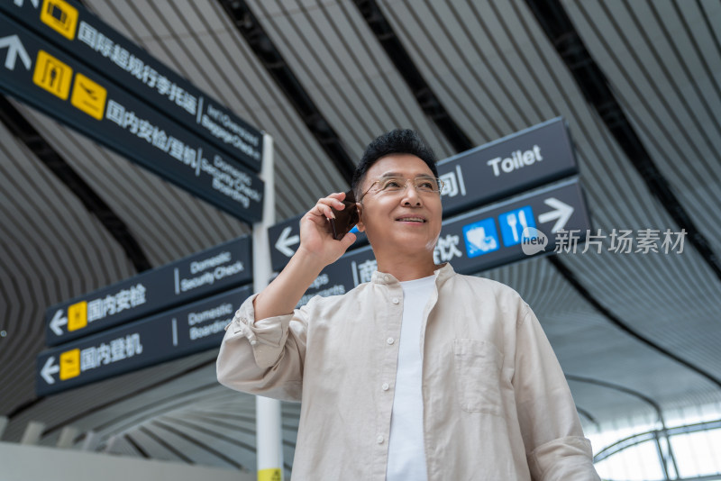 老年男人在机场打电话