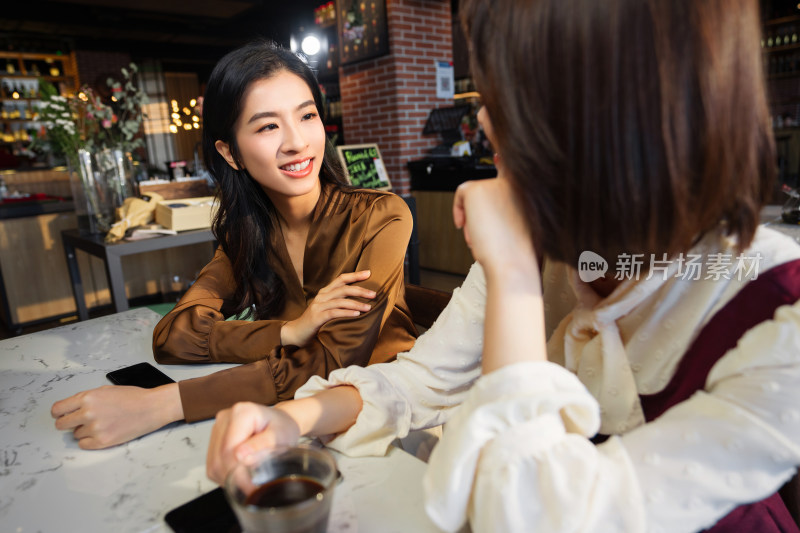 年轻闺蜜在咖啡馆聊天