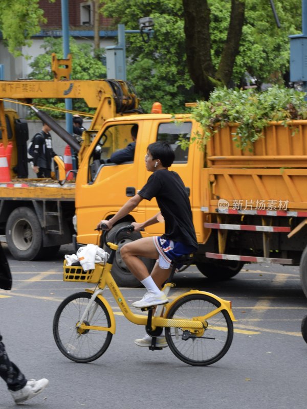 男子骑行黄色共享单车