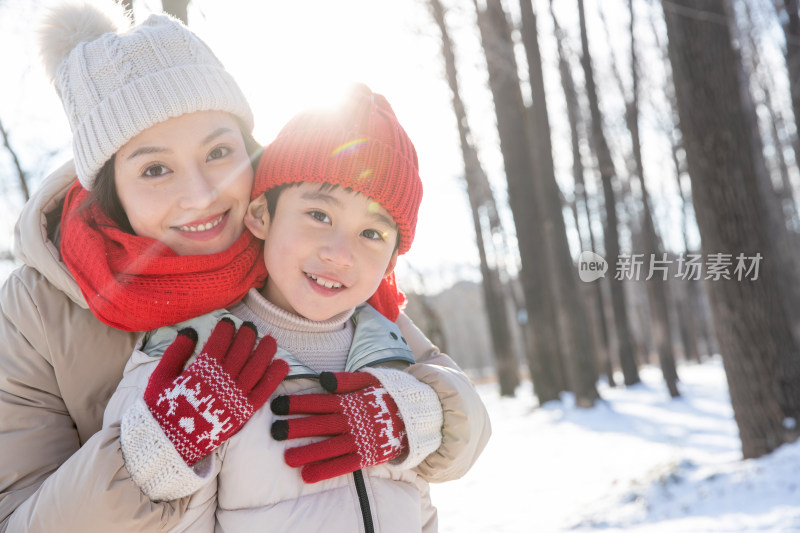 年轻妈妈带着孩子在雪地玩耍