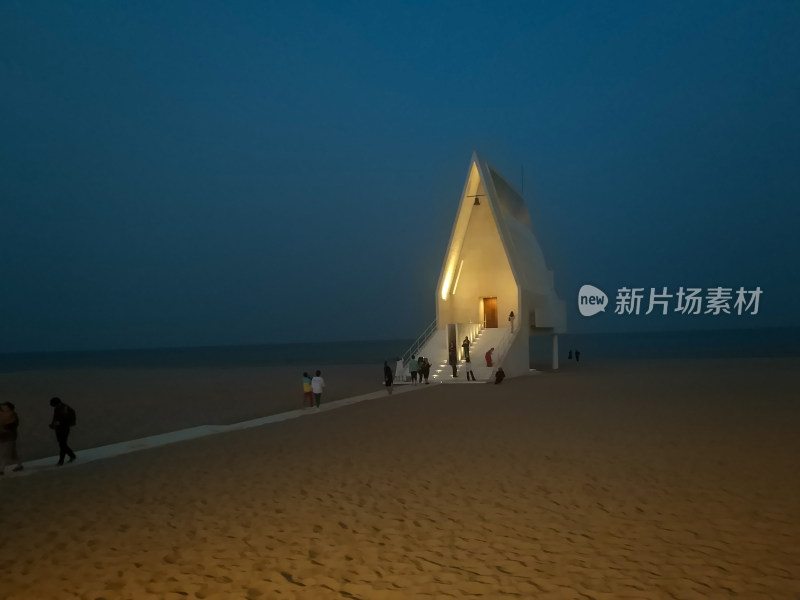 夜色下海边沙滩上的特色建筑