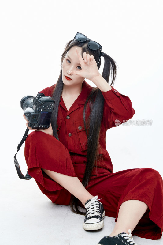 手持相机的亚洲戴墨镜年轻少女的肖像人像