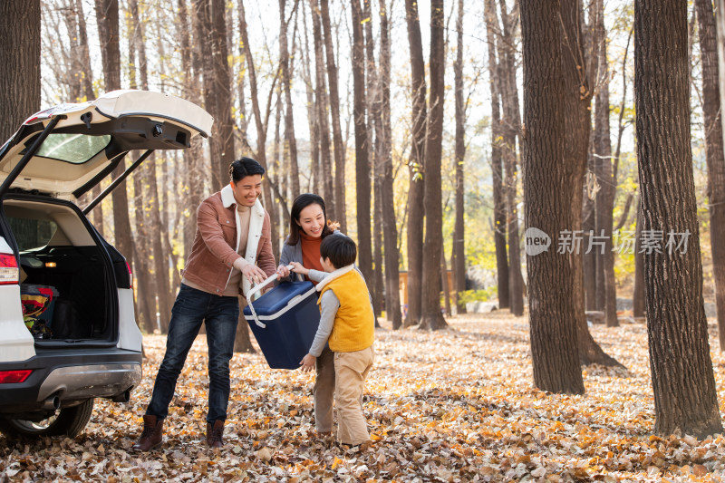 秋天户外郊游的幸福家庭一起在卸行李