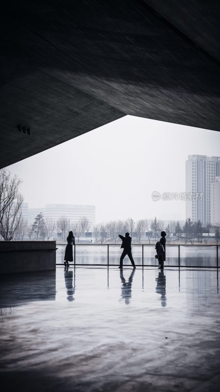 建筑下三人观赏城市景观