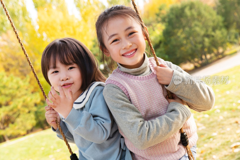 两个女孩在公园里荡秋千