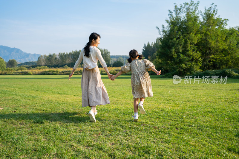 妈妈和女儿在草地上奔跑