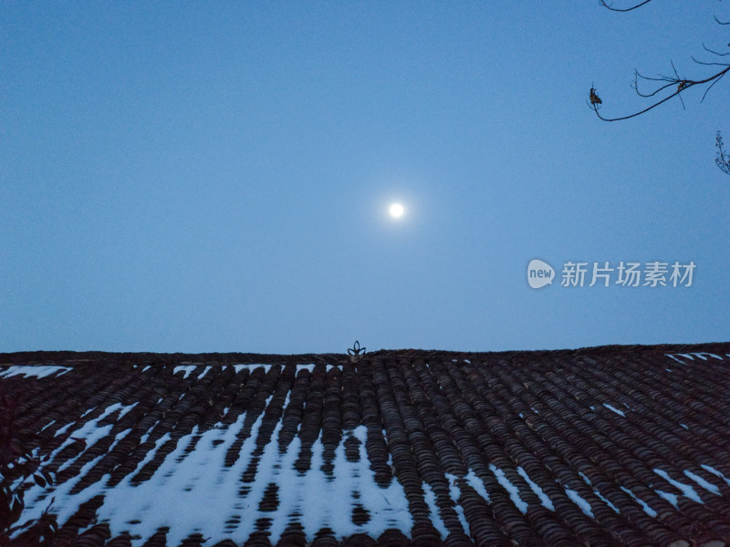 月光下带雪屋顶的景象