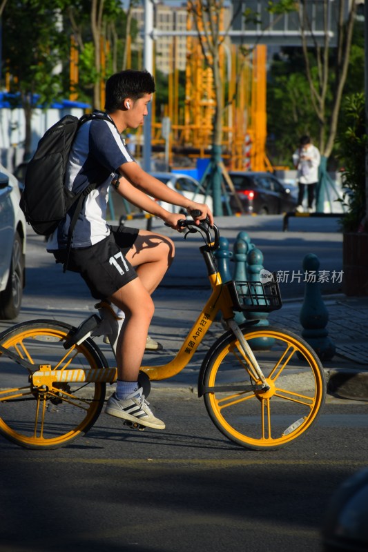 男子骑行黄色共享单车