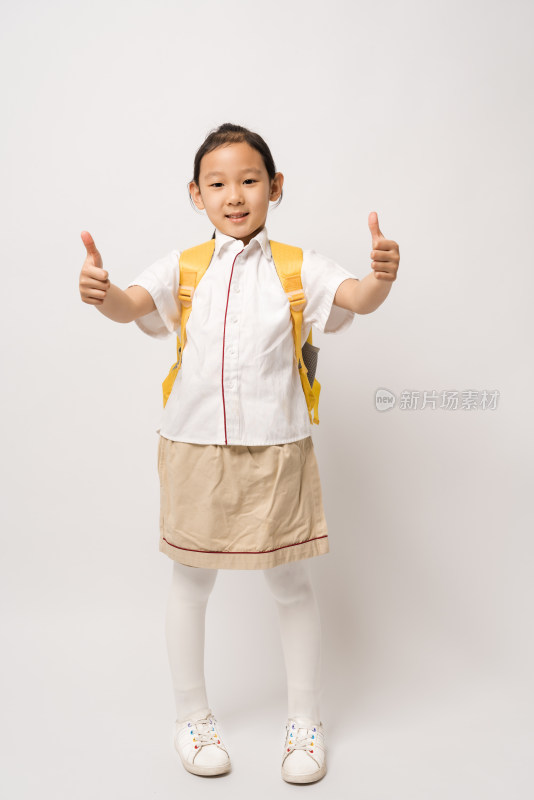白色背景前双手竖大拇指的中国女孩