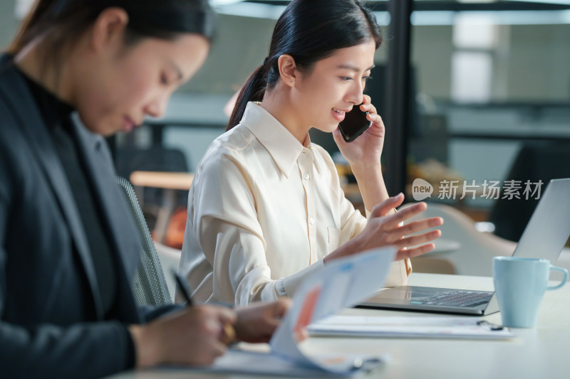 在办公室里打电话的商务女士