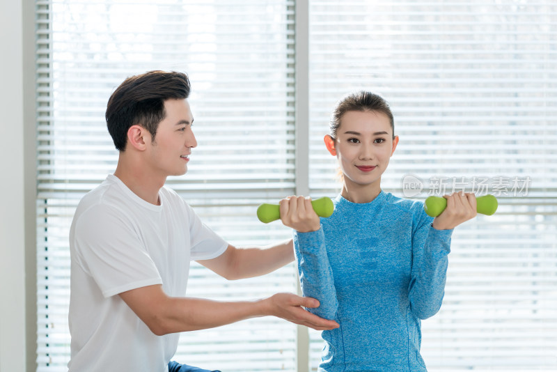 年轻女子在私教的指导下健身