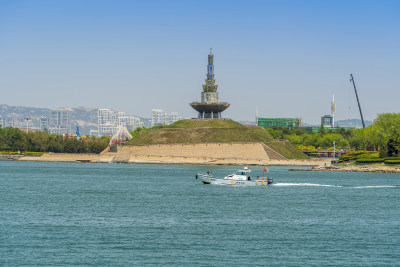 一艘快艇驶过山东省日照市万平口景区潮汐塔