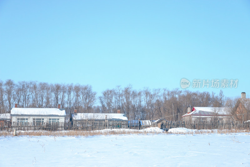 雪后乡村景象，屋顶和地面覆盖着白雪