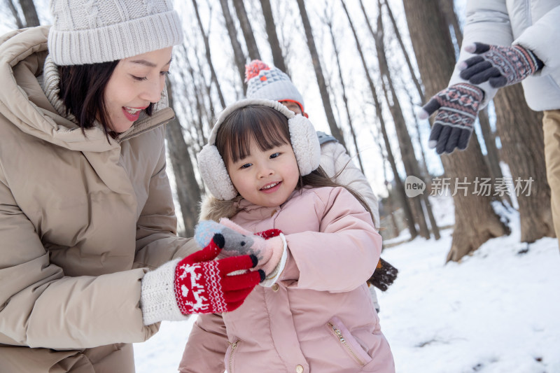 一家三口在雪地里玩耍