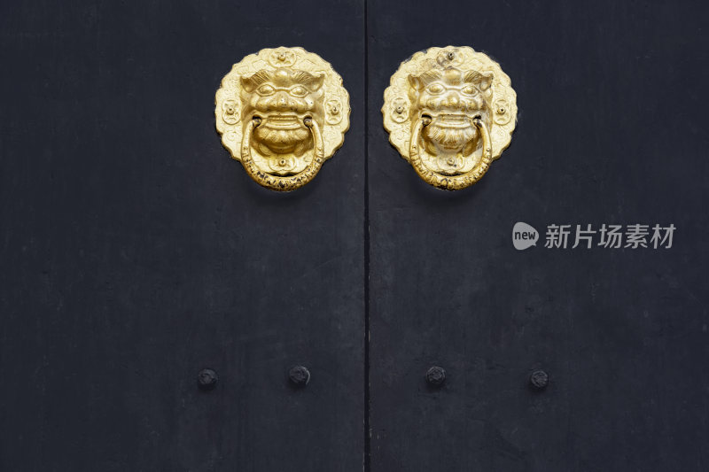 黑漆木门上的两个金色门环