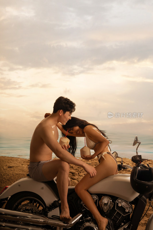青年情侣在沙滩上喝椰汁