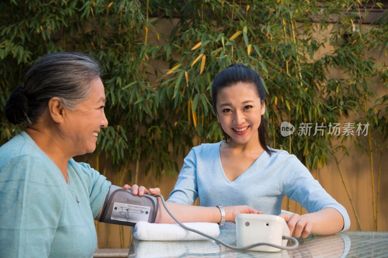 年轻女人给老年女人量血压