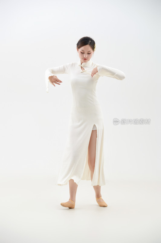 穿着白色旗袍头戴绢花的跳古典舞的少女
